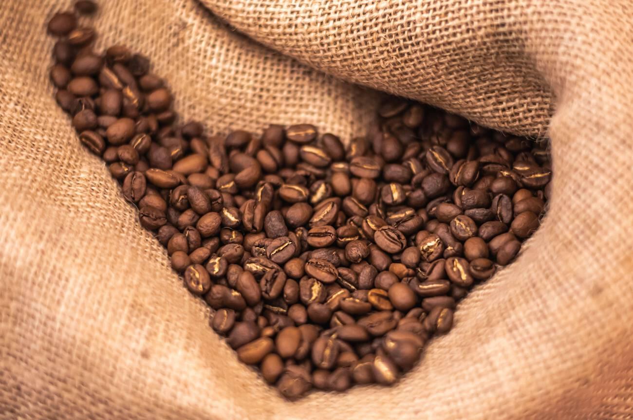 Roasted brown coffee beans or seeds in a jute sack, close up Roasted brown coffee beans or seeds in a jute sack, close up