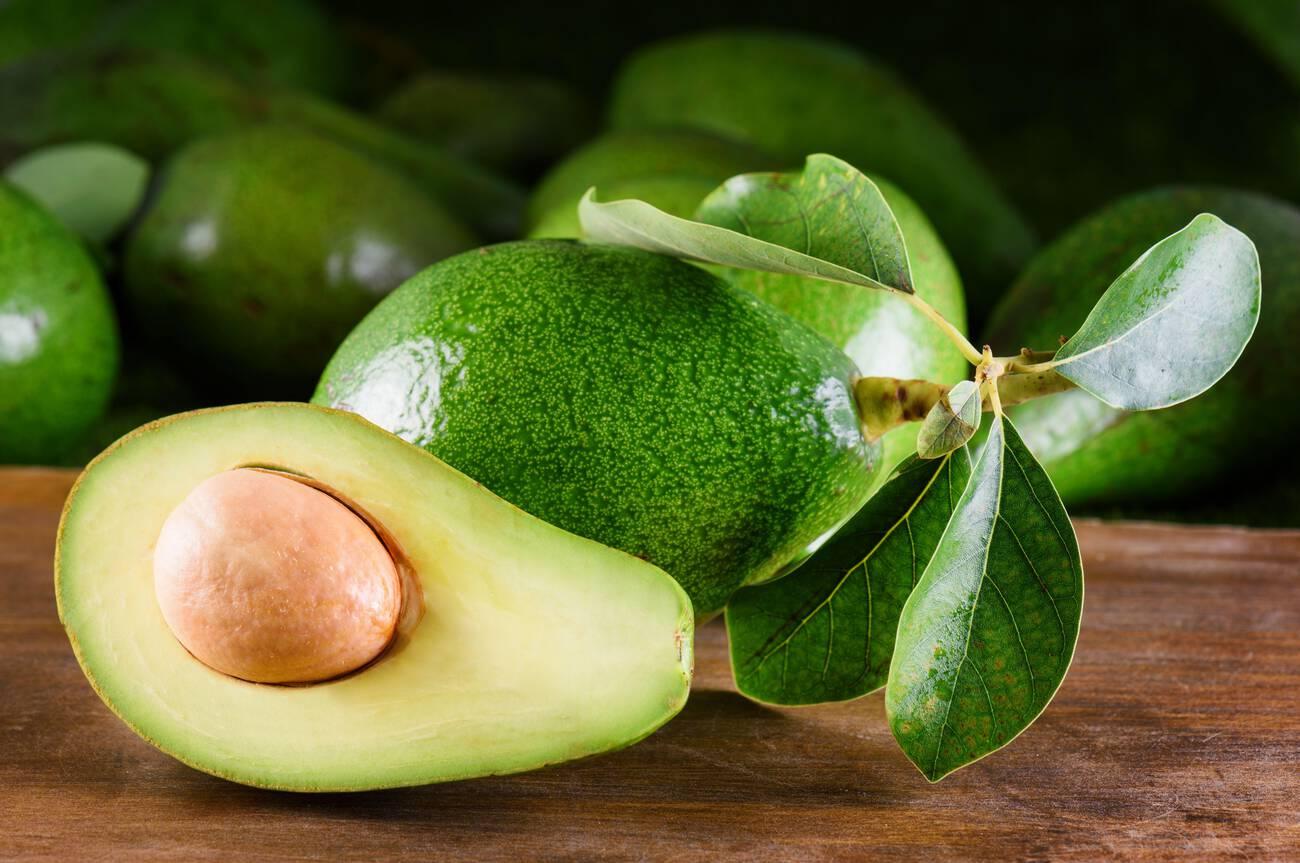 Fresh ripe avocado with green leaves.