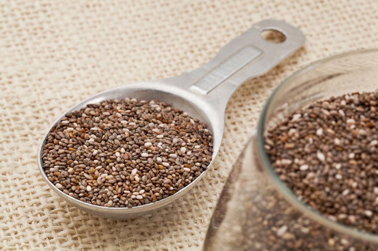 chia seeds in glass jar and on measuring aluminum tablespoon