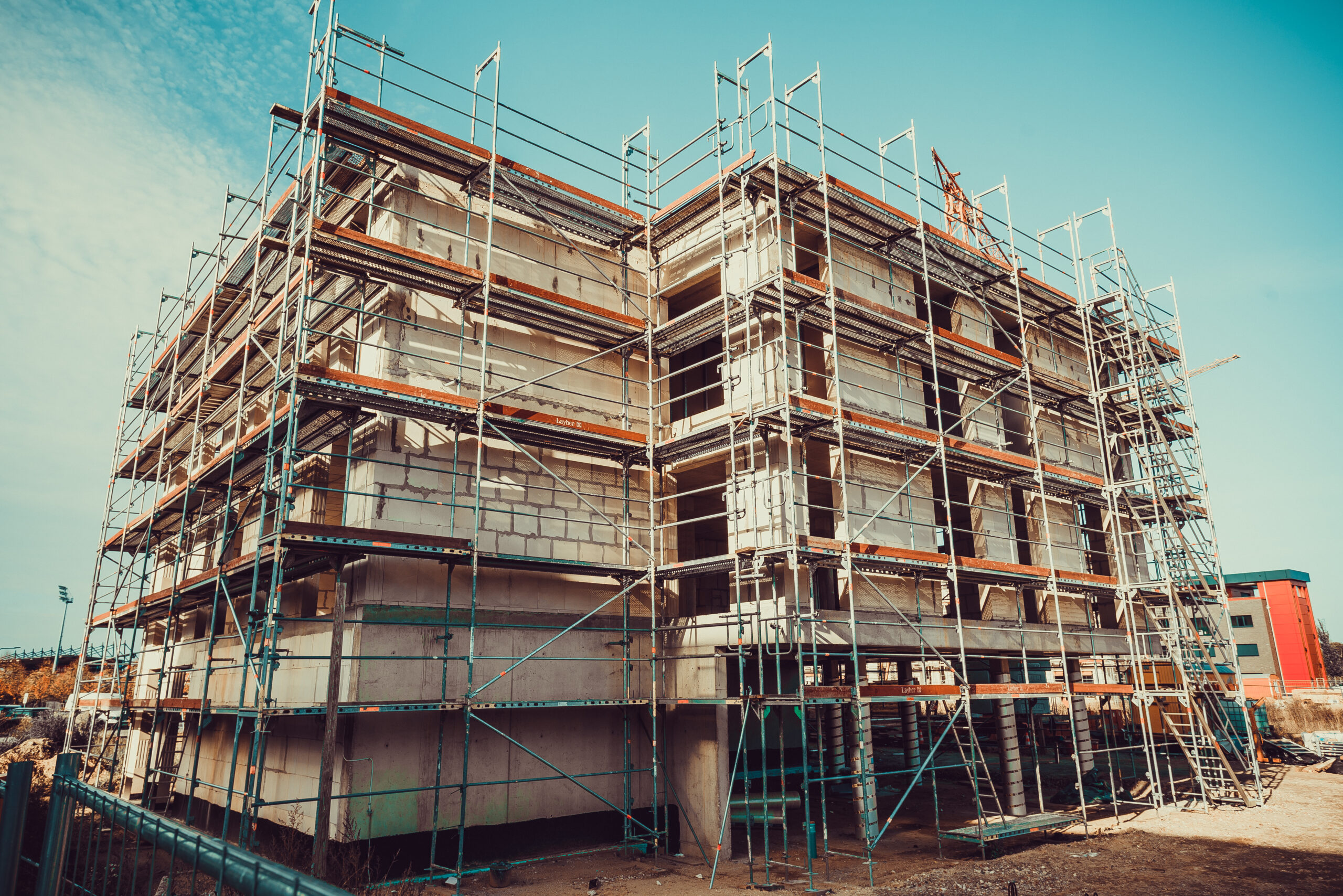 Unfinished affordable housing buildings with scaffolding at a construction site