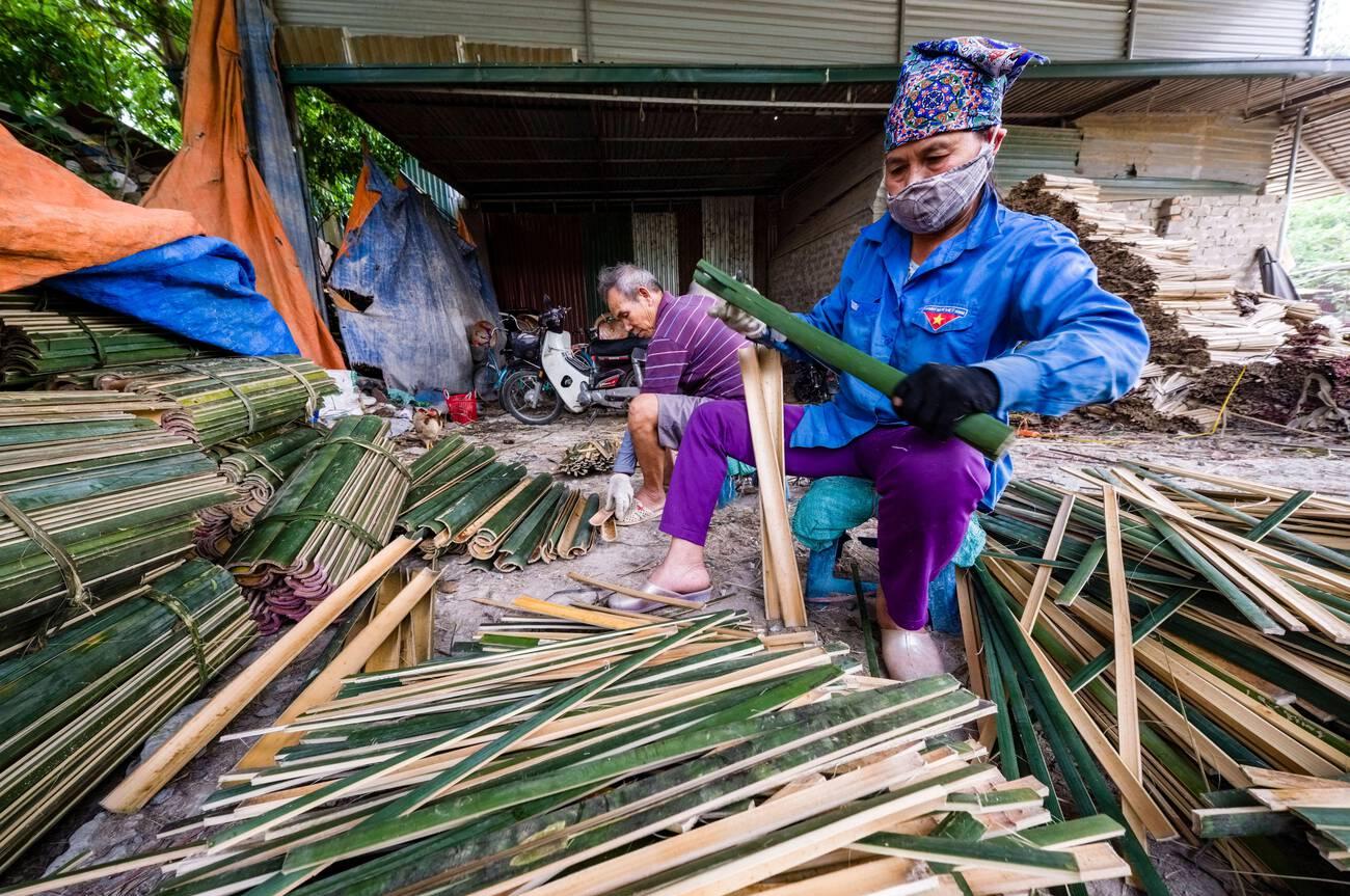 alamy_2SXXCTF A woman splits bamboo with a knife for the later production of incense sticks.