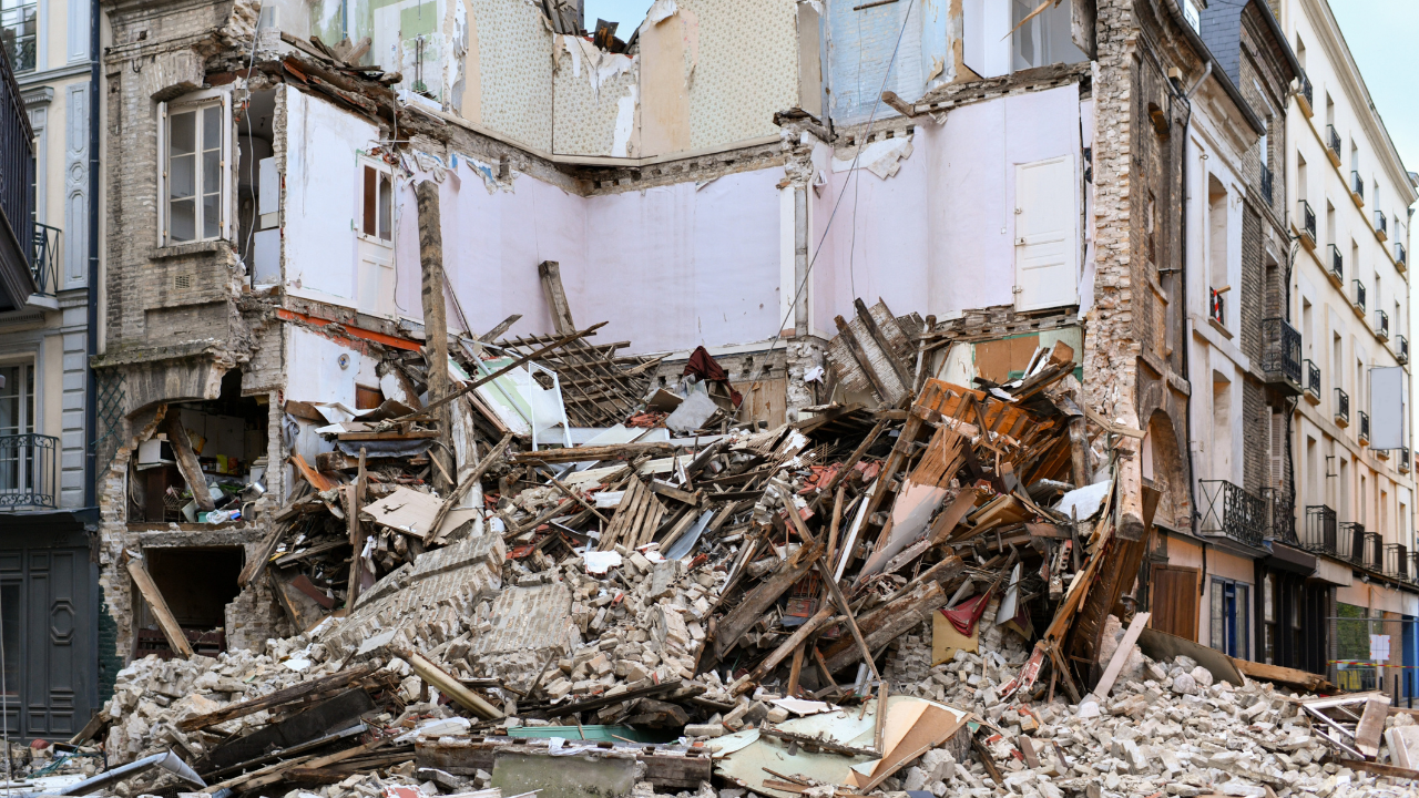 Describe a scene of building destruction, focusing on the details of the rubble and twisted reba